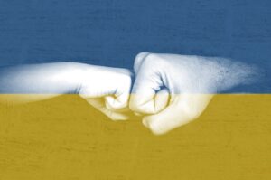 Dwie dłonie na tle flagi Ukrainy